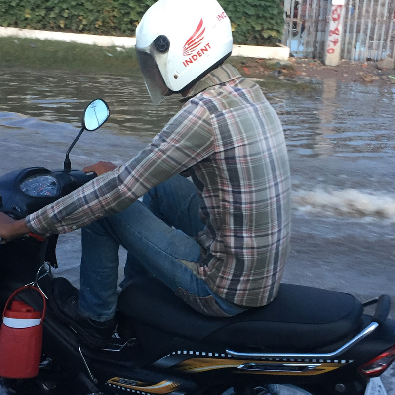 洪水の中をバイクに乗る男性