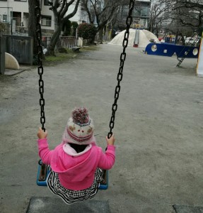 公園でブランコに乗る娘