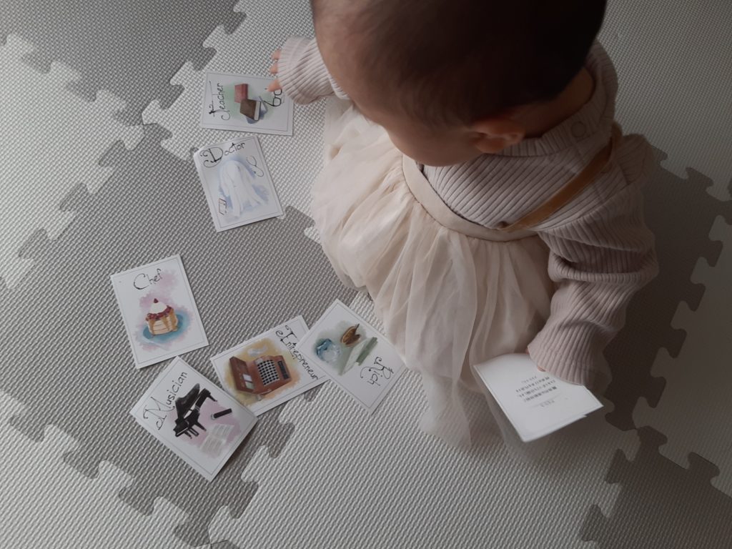 1歳の女の子が選び取りカードで遊んでいる様子。