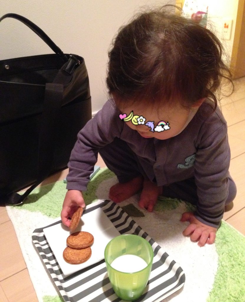 1歳の娘がサンタのクッキーを食べようとしている